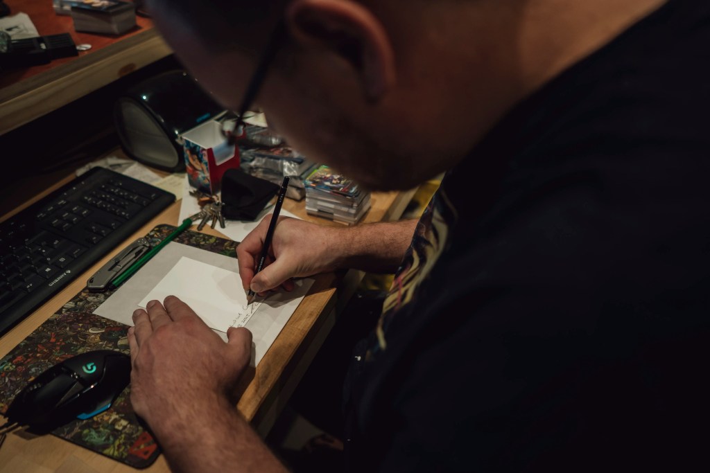 Corné van Dooren, owner of Kai of Cards, signing the Fine Art Print 1/3. As the original seller of the booster box, his signature authenticates the Living Provenance of the Arknight Shard.